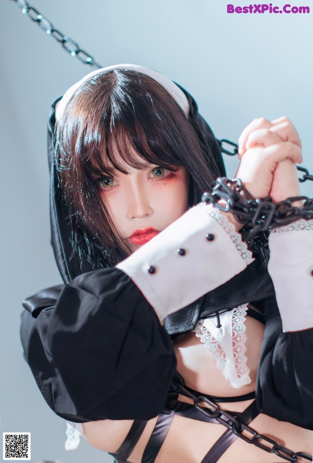 A woman in a black and white outfit is chained to a chain.