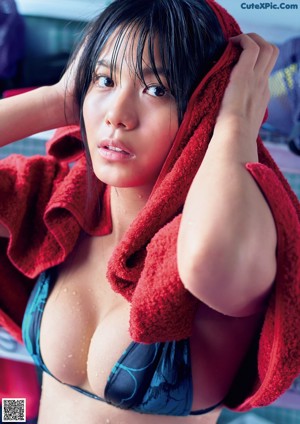 A woman in a red bikini sitting on the beach.