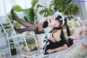 A woman dressed as a maid sitting on a chair.