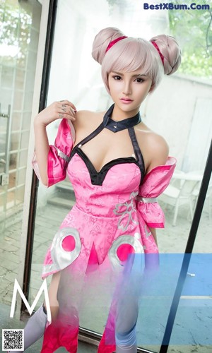 A woman in a pink dress holding a pink umbrella.