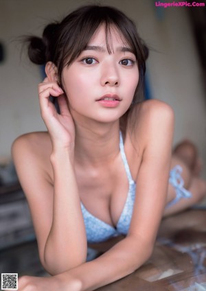 A woman in a blue bikini laying on a table.