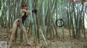 A woman in a black and red outfit holding a sword.