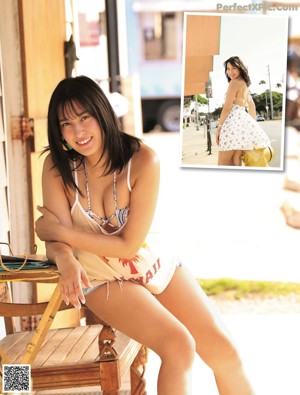 A woman in a black bikini standing on a beach.