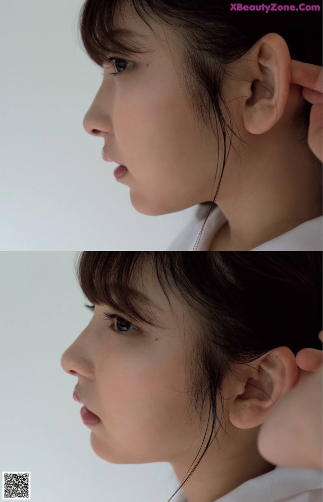 A close up of a woman's face with her hand on her ear.