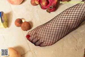 A woman in a white lingerie sitting on a kitchen counter.