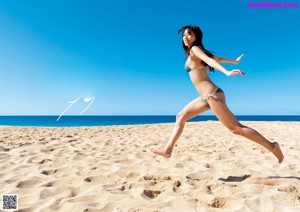 A woman in a bikini walking up some stairs.