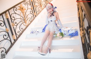 A woman in a white dress holding a bouquet of flowers.