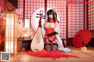 A woman in a red and black outfit sitting on a table.
