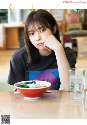 A woman sitting on the floor in front of a table.