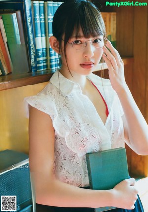 A woman sitting on the floor in a white sweater and panties.