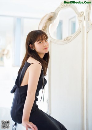 A woman in a black dress posing for a picture.