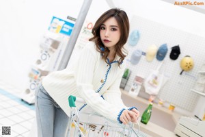 A woman sitting at a counter holding a cup of ice cream.