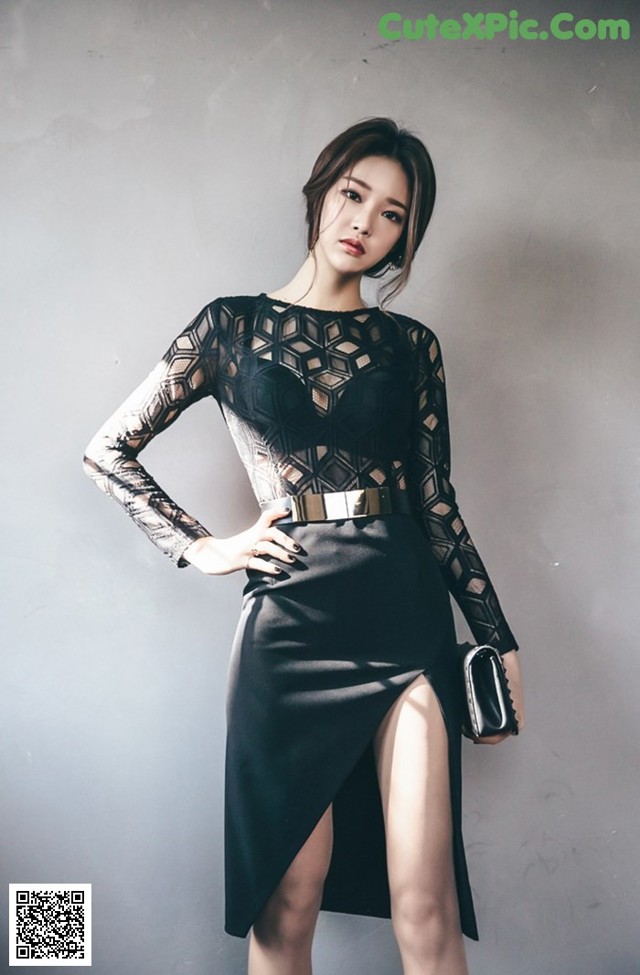 A woman in a black dress posing for a picture.