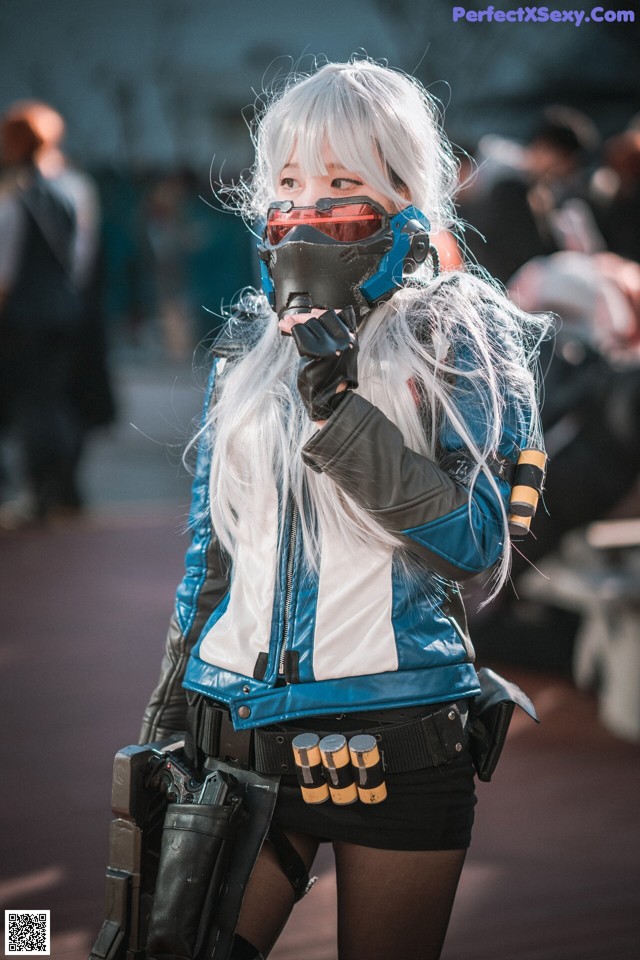 A woman in a blue and white outfit holding a gun.